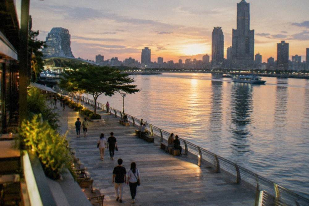 Evening lights reflecting on a riverfront promenade in a Taiwanese city