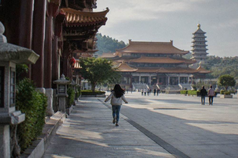 Temple halls with tiered roofs seen across a wide courtyard at a Buddhist monastery