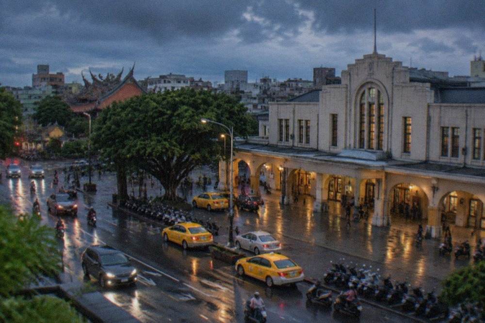Rain clouds gathering over a Taiwanese city skyline with wet streets below