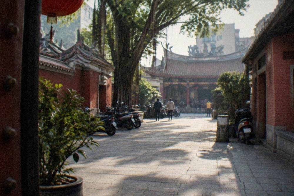A traditional temple courtyard with red walls and stone paving in Tainan's historic center