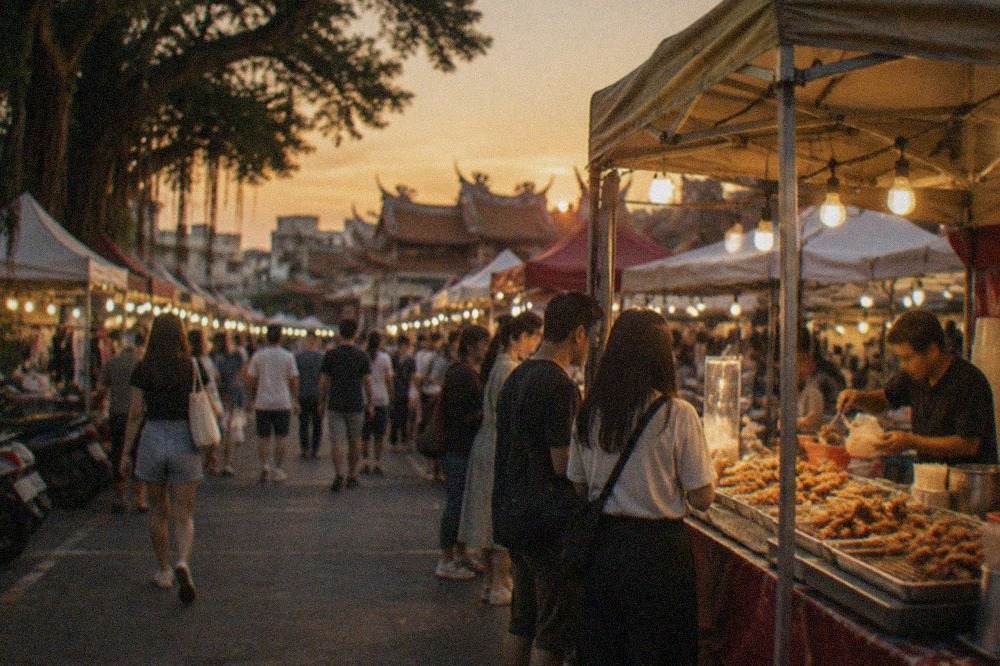 A night market stall in Tainan with trays of fried snacks and a vendor serving customers