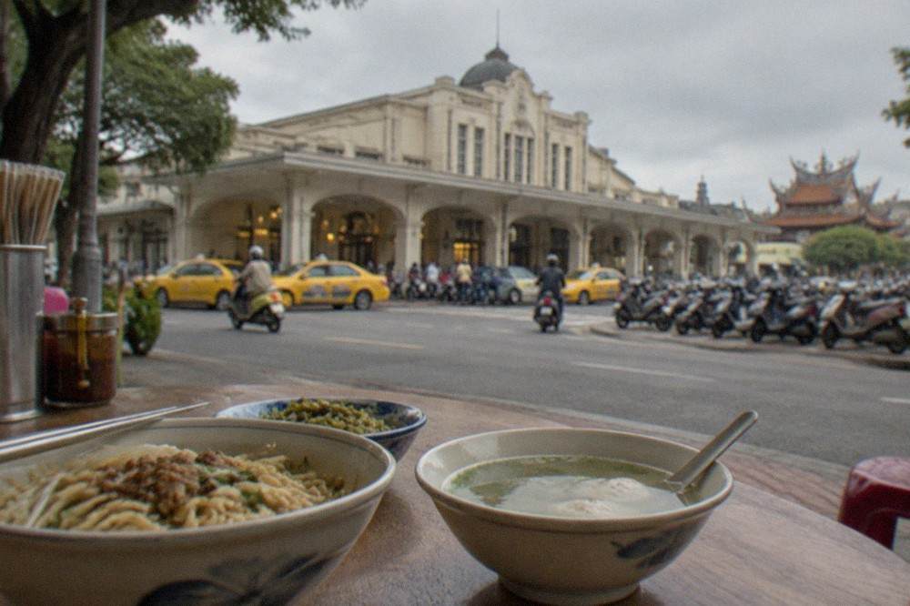 Small bowls of noodles and soup arranged on a wooden table at a Tainan eatery