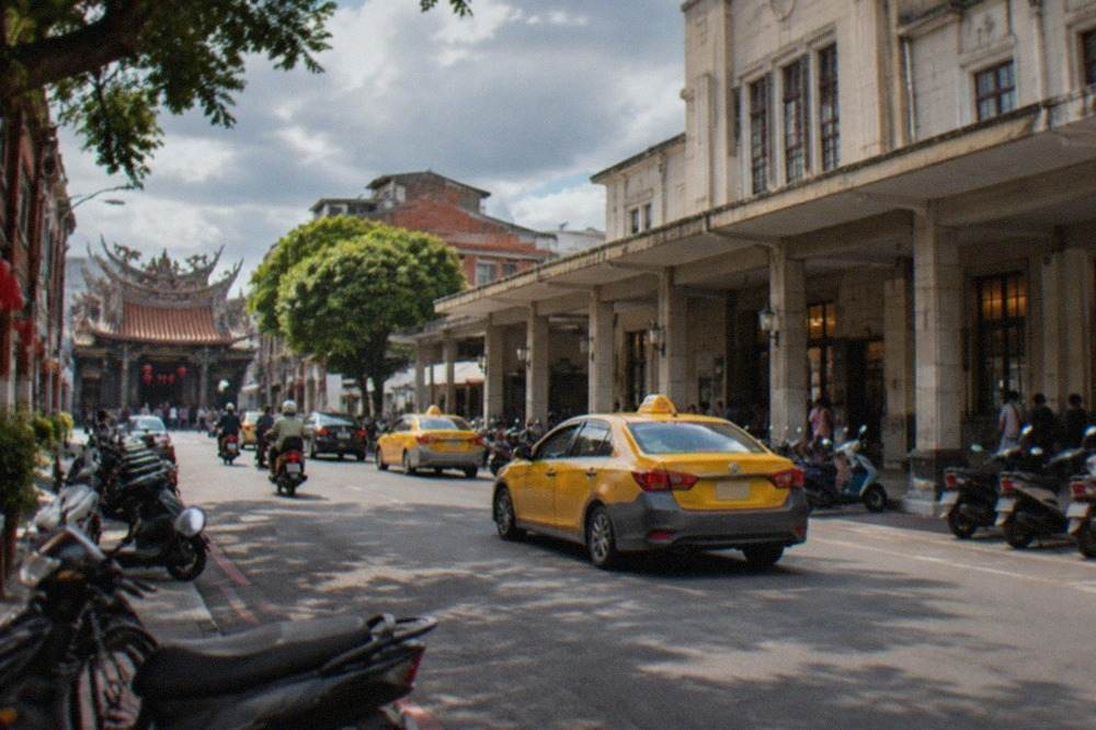 A historic Tainan street with old brick buildings and a traditional temple gateway