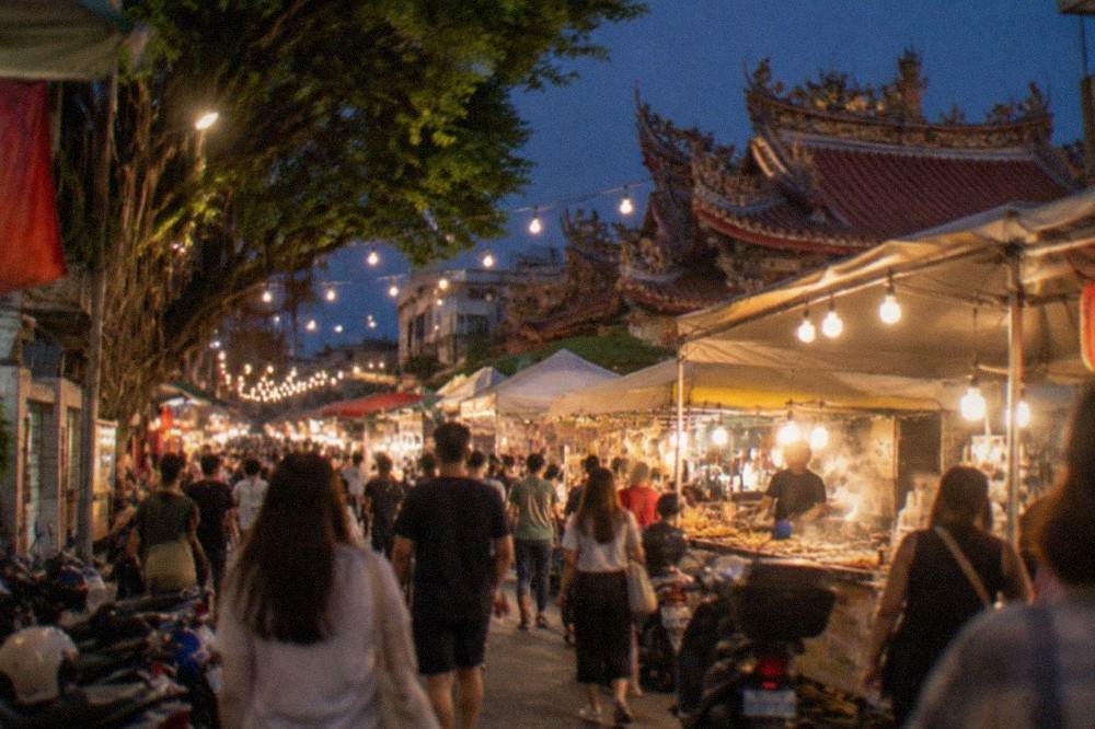 A lantern-lit night market lane in Tainan crowded with food stalls and shoppers