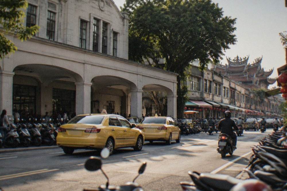 A historic Tainan street with low shophouses and a temple roofline in the evening
