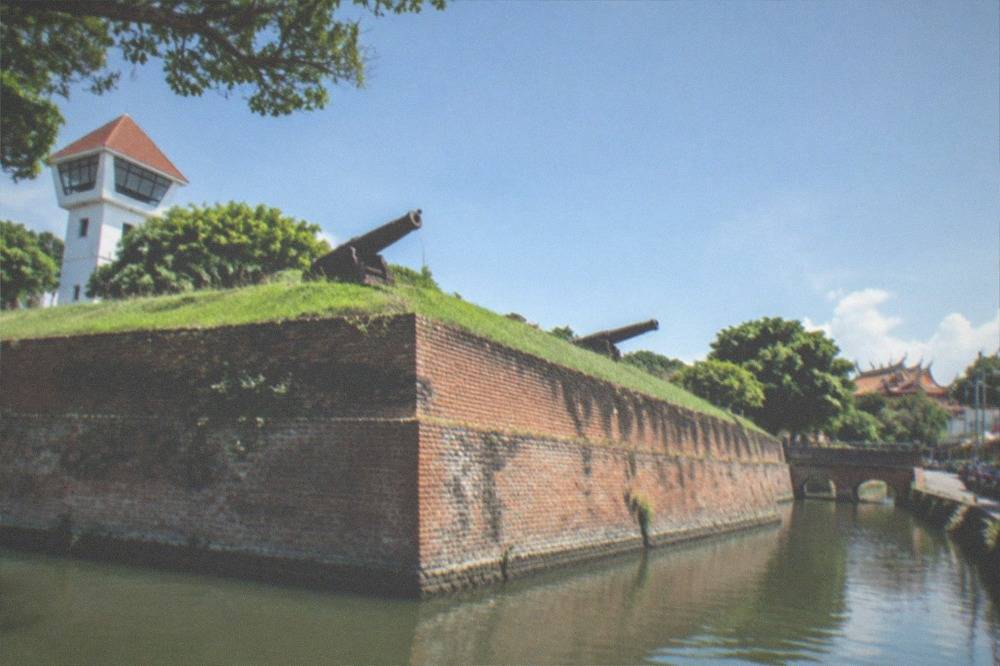 Grass-topped earthen ramparts of the Eternal Golden Castle with old cannon barrels on display