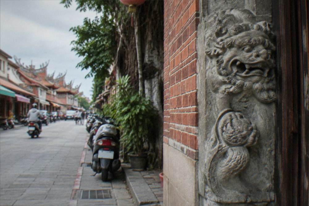 A stone sword lion carving set into the wall of an old Anping doorway