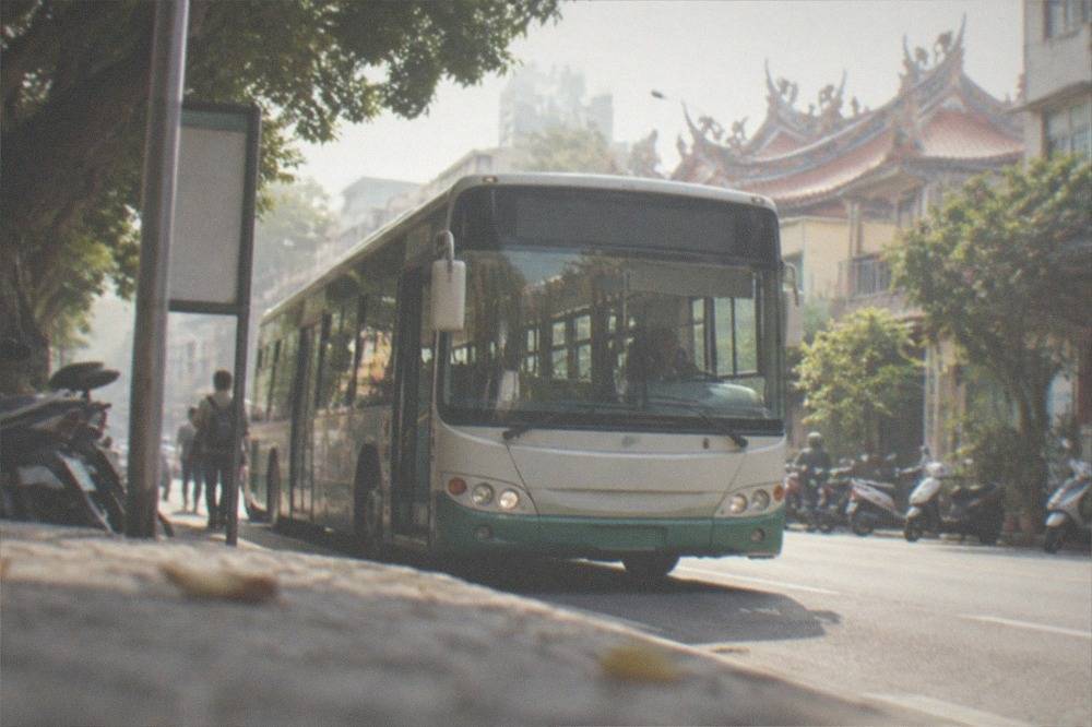 A Tainan city bus at a stop on a sunny street