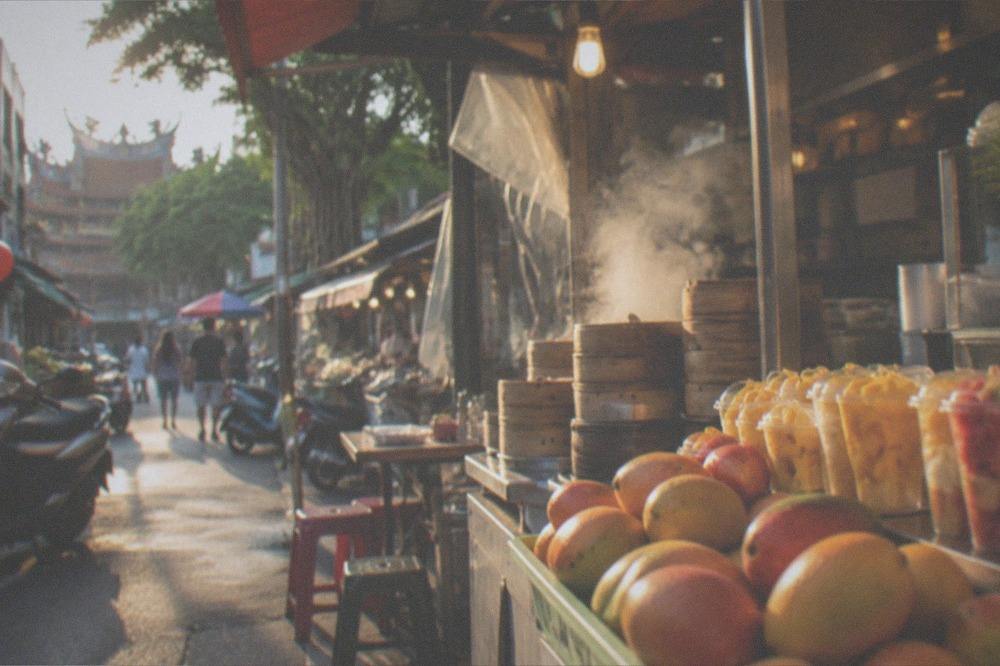 Fresh mangoes and fruit cups displayed at a street dessert stall