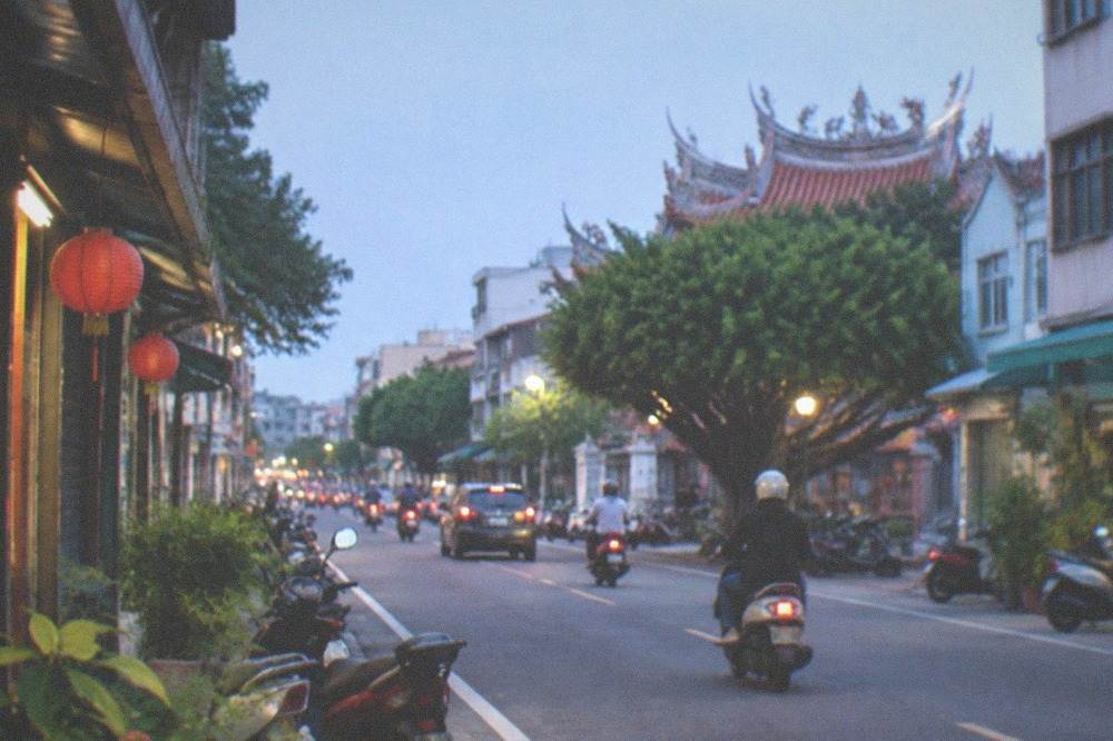 A wide planned boulevard with modern low buildings, trees and a clear sky in a new town district