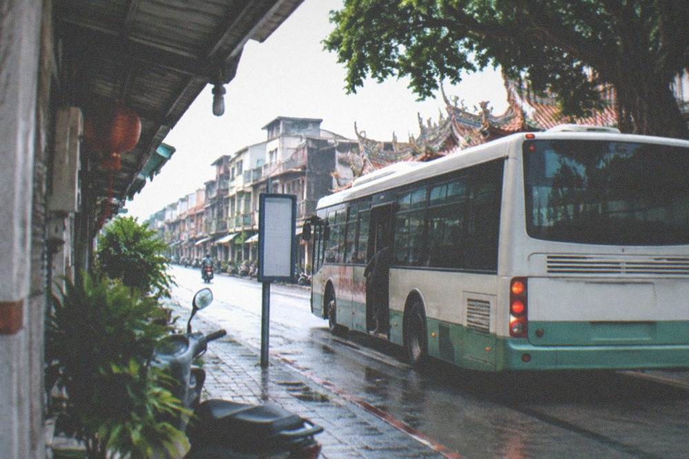 A city bus stopped at a roadside stop in a small Taiwanese town