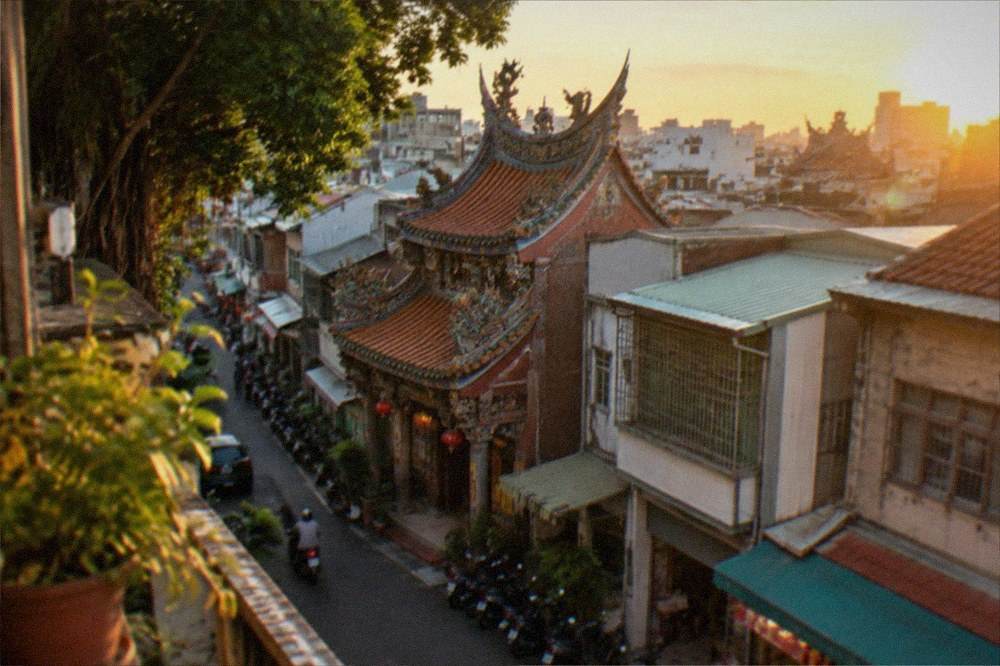 Aerial view of Tainan temple roofs with the old city skyline at golden hour