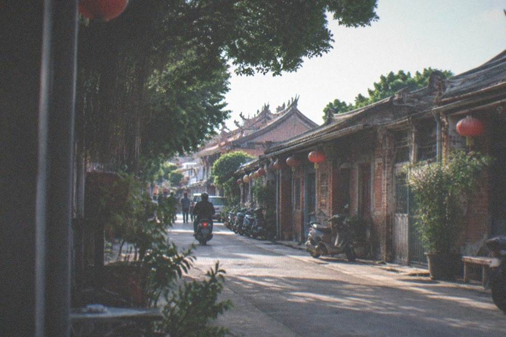 A narrow old street lined with low brick houses and hanging shop signs in Anping