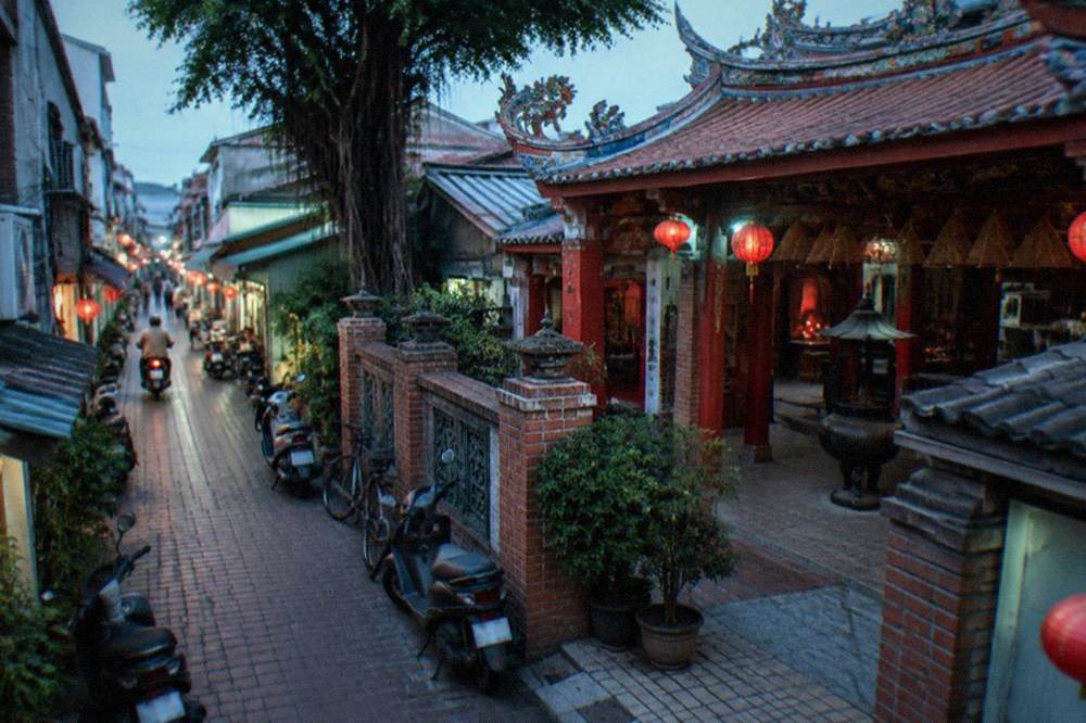 A red and gold temple courtyard with incense coils hanging under the roof
