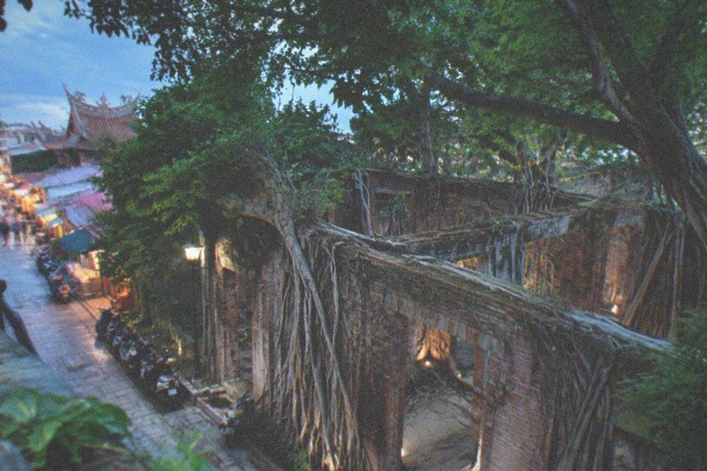 Exterior view of the brick warehouse at the Anping Tree House with tree canopy