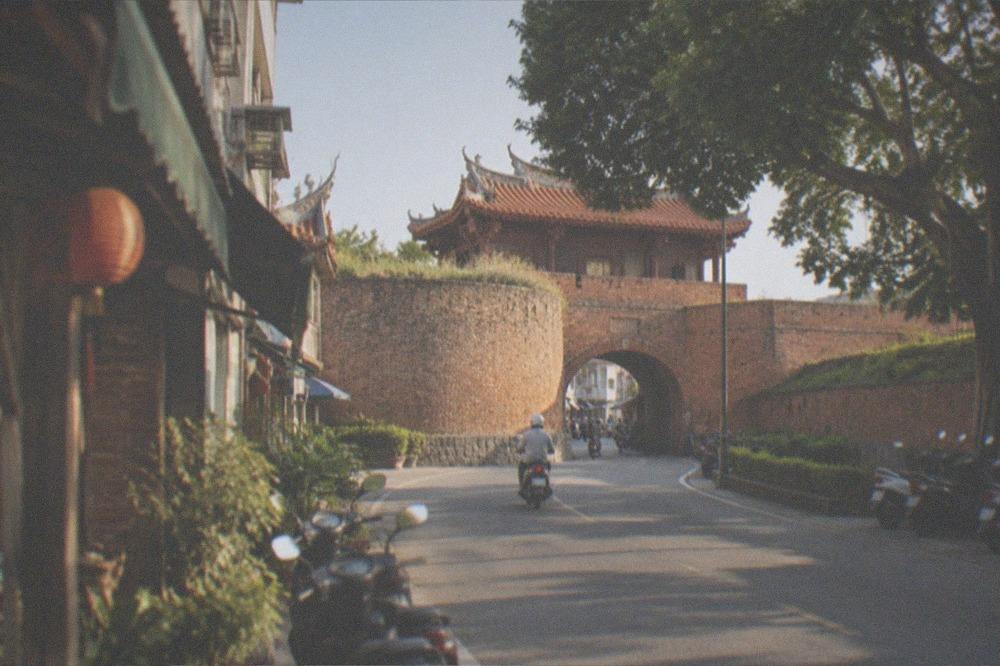 Weathered red brick rampart walls with grass growing along the top