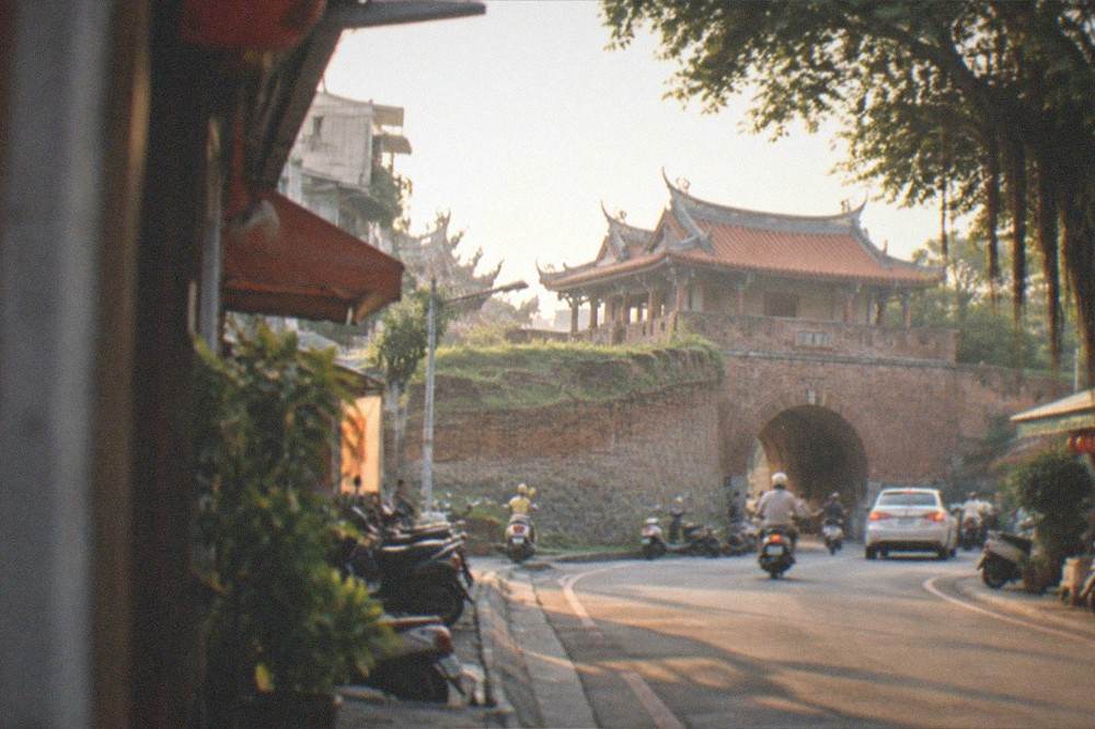 The stone gate at dusk with warm light on the old walls