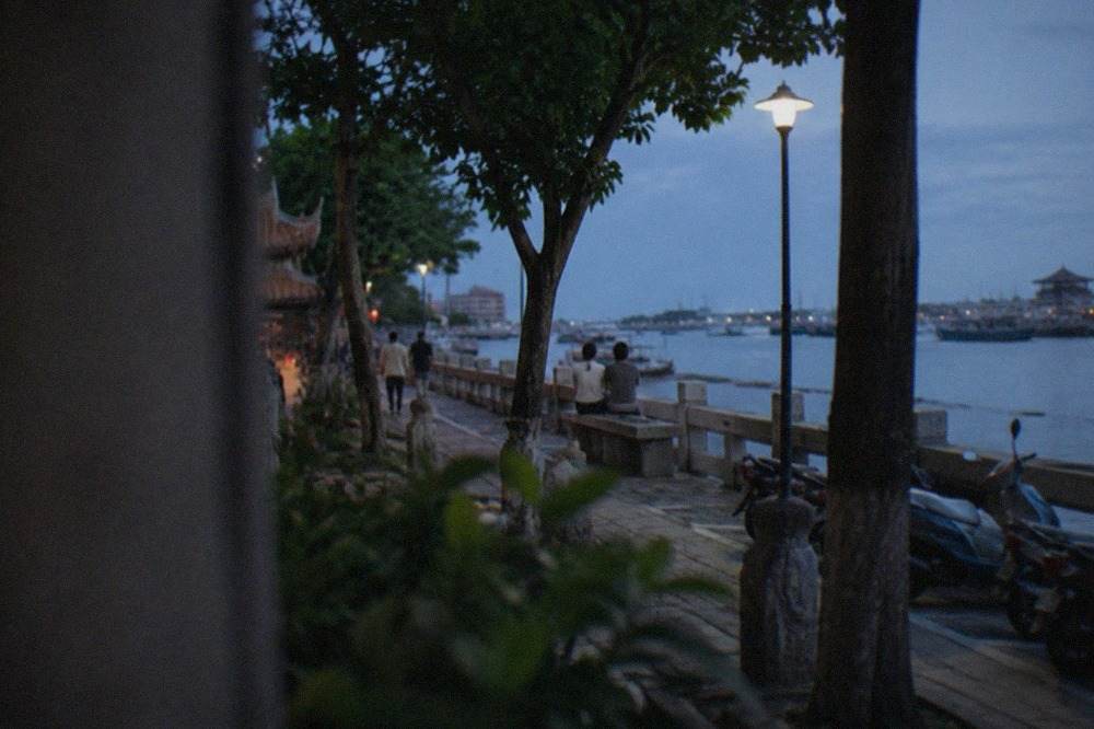 Waterfront park in Anping, Tainan, with trees, a stone walkway and the harbor in the background