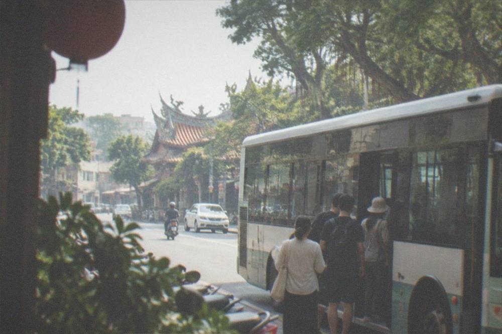 A city bus at a stop in Tainan with passengers boarding