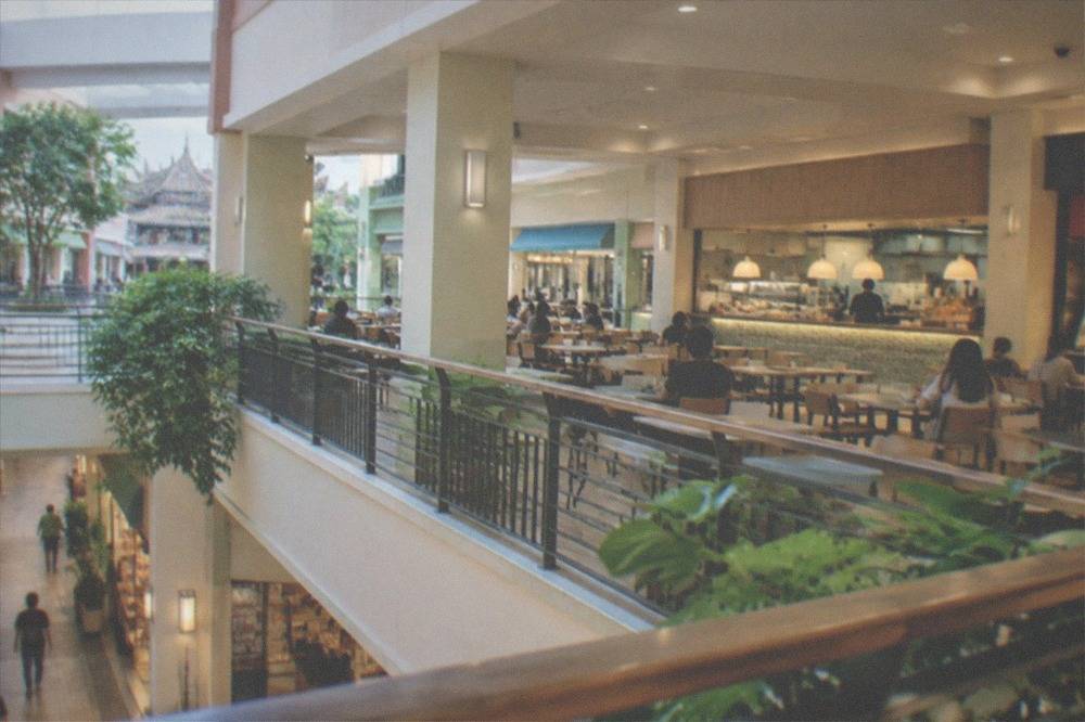 An indoor mall food court with tables and restaurant counters during a quiet afternoon