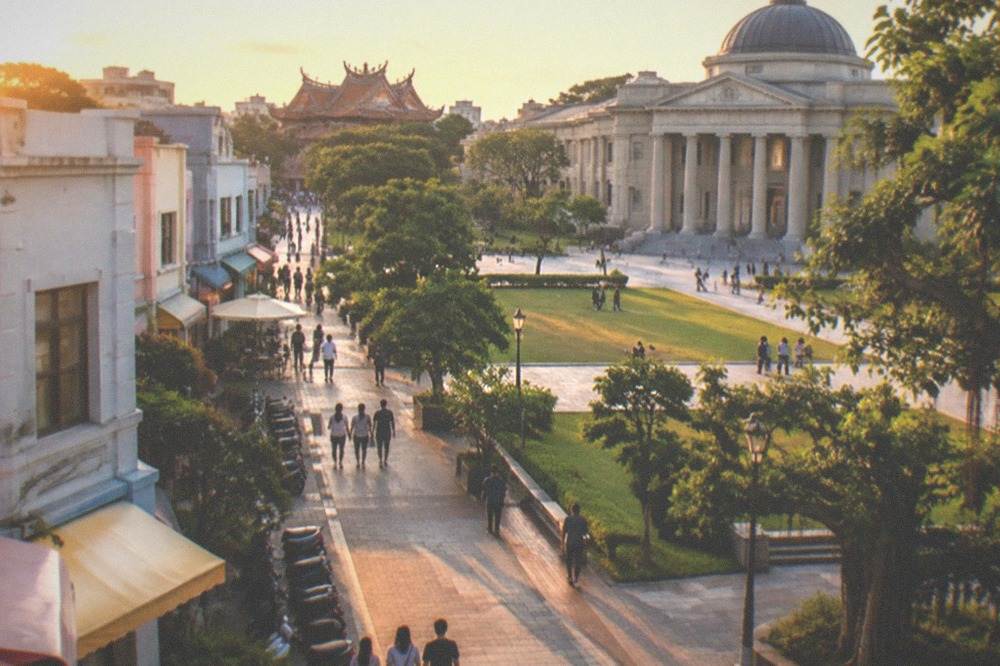A museum building with classical architecture surrounded by lawns and a wide plaza