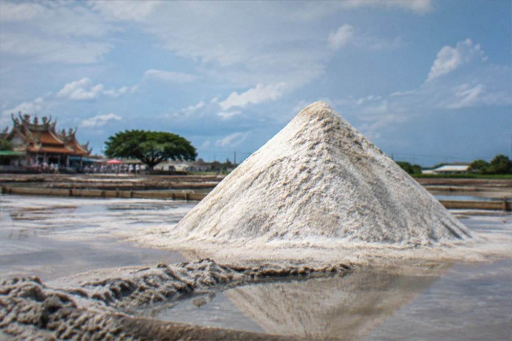 A white salt mound seen from a distance across a wide open recreation area