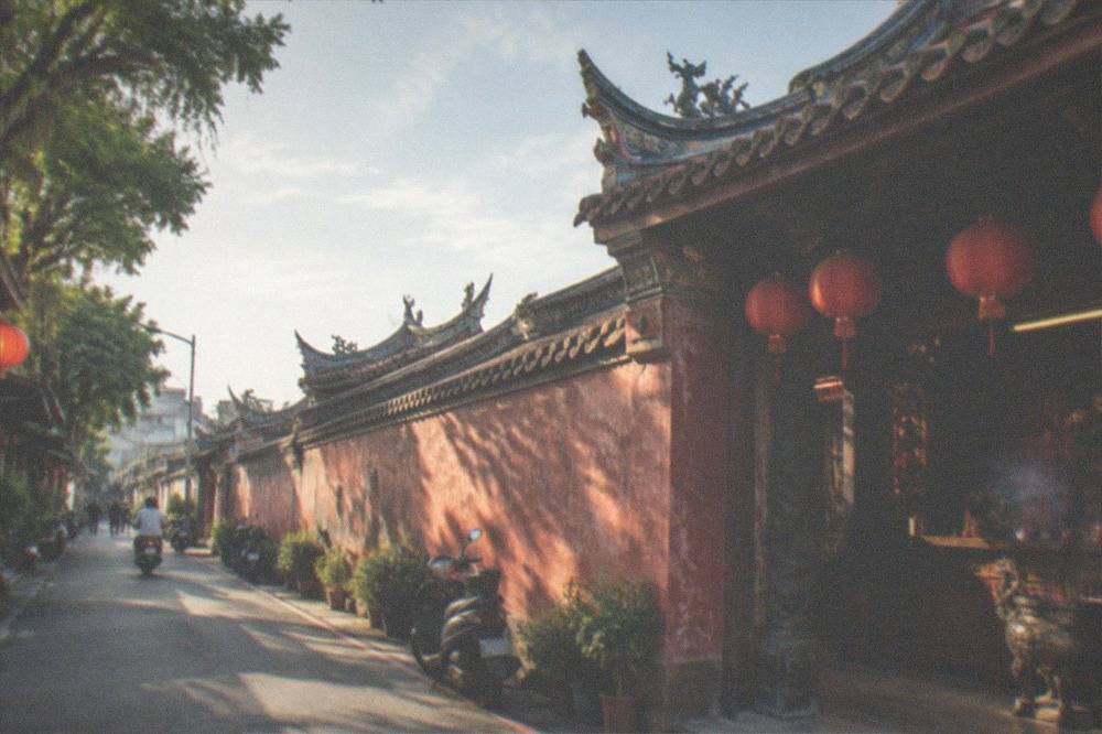 Interior of a Taiwanese temple with red lanterns, incense and a carved altar