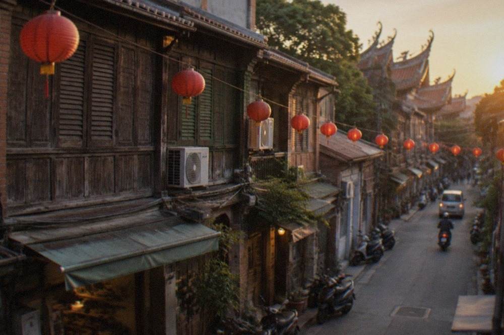 Old two-story street houses with wooden facades along a narrow lane at dusk