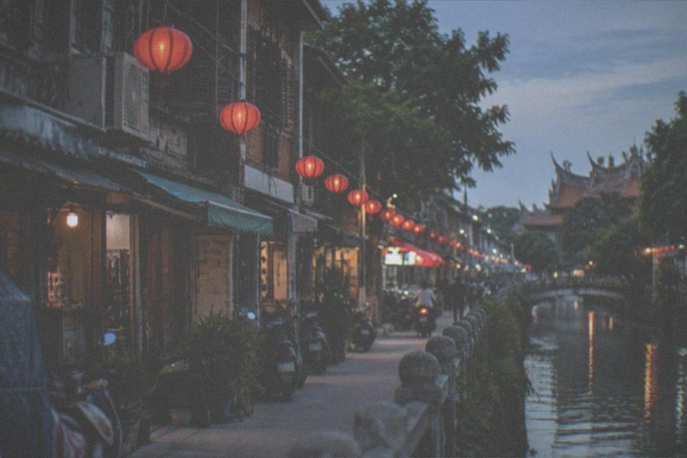 A canal-side path in Tainan with old buildings along the water