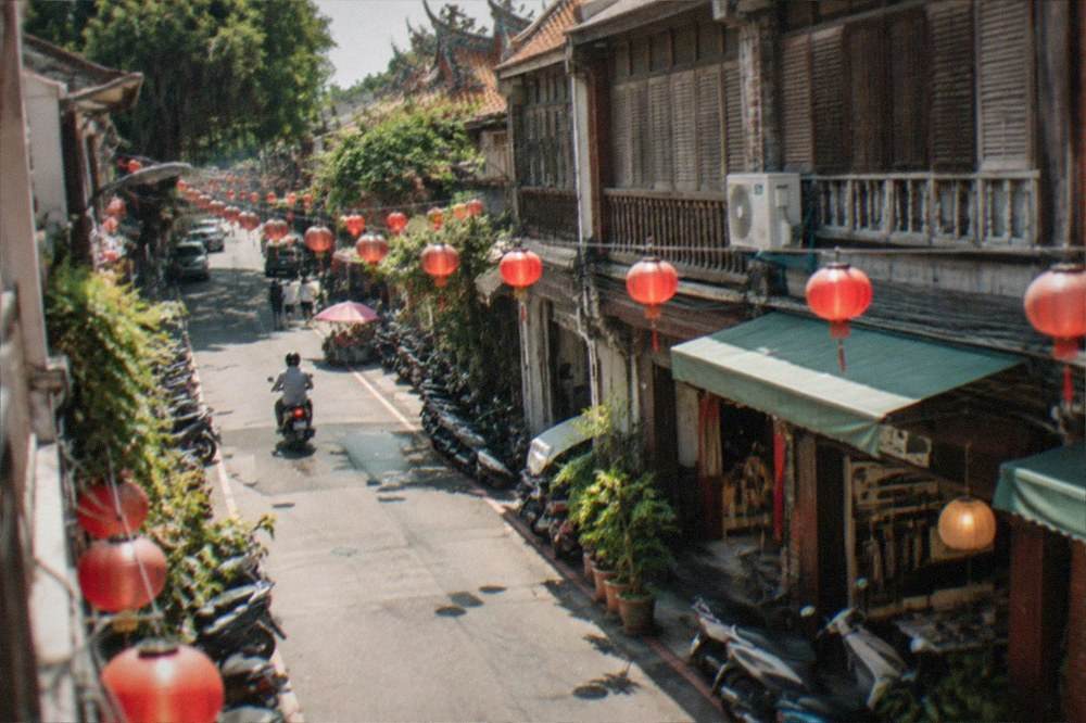 Lanterns and shop lights glowing along a narrow street after dark