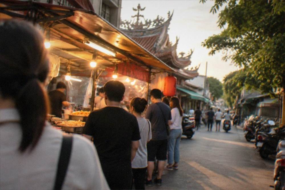 A night market stall glowing under warm lights with a queue of customers