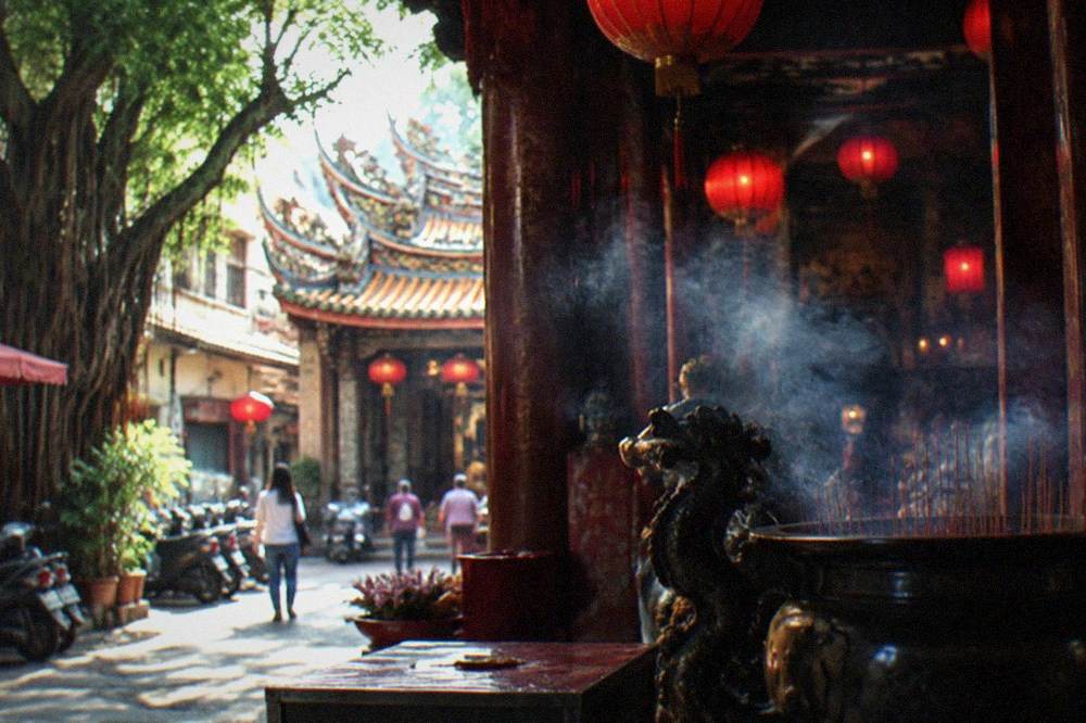 Interior of a Taiwanese folk temple with red lanterns, hanging plaques and an altar lit by electric candles