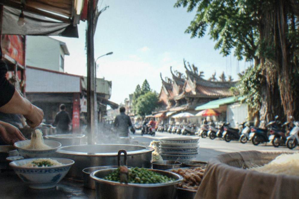 Close-up of noodle bowls being prepared at a market counter