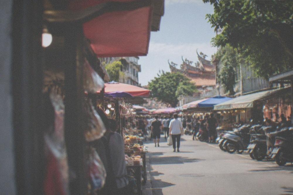 Wide view of night market lanes with stall lights stretching into the distance