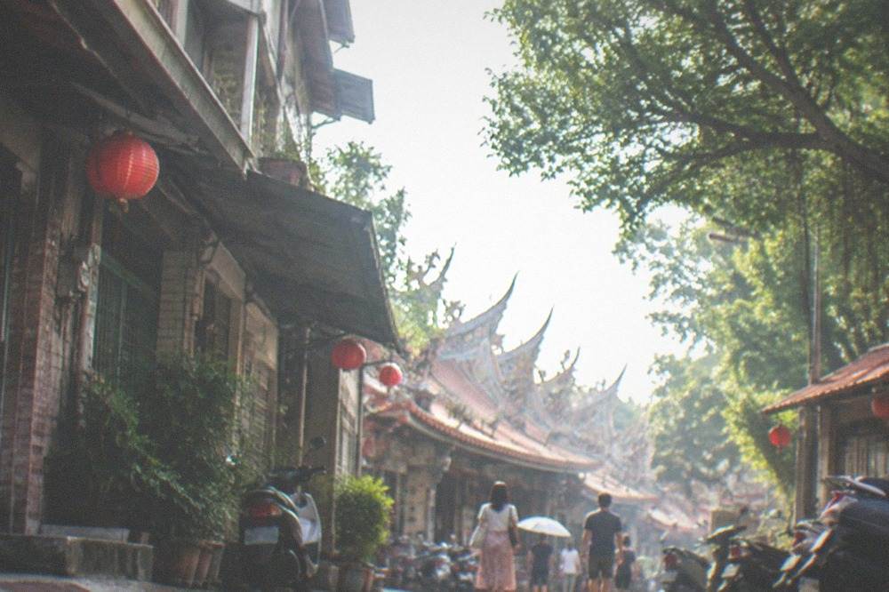Visitors walking past old shopfronts on a narrow Taiwanese old street