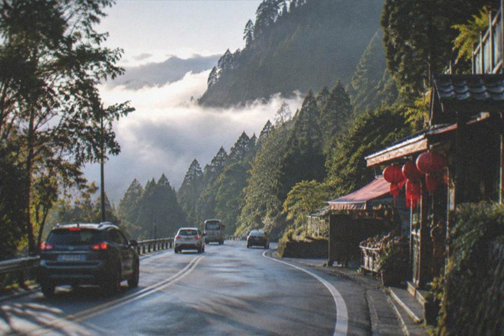 Mountain highway curving through dense green forest on the approach to Alishan