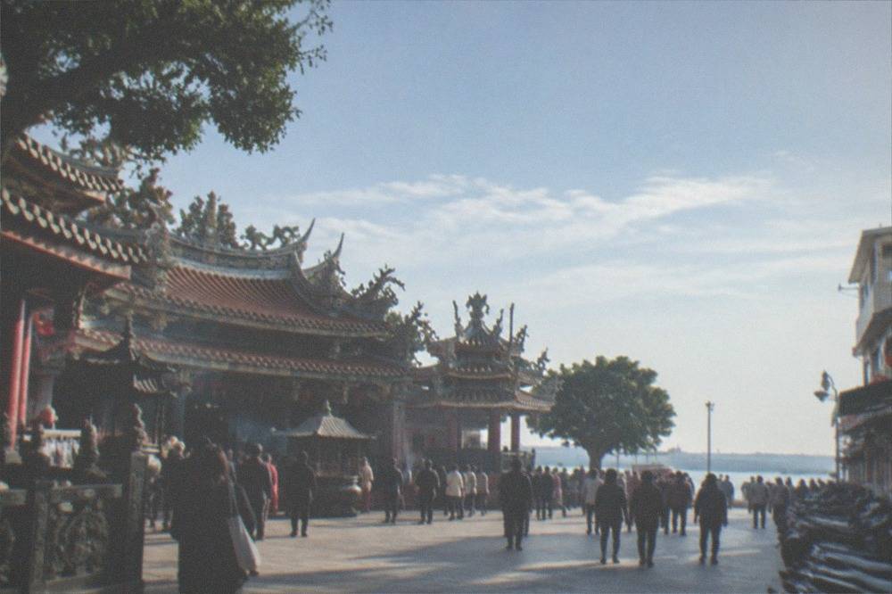 A large ornate temple courtyard with crowds of visitors at a coastal Taiwanese pilgrimage temple