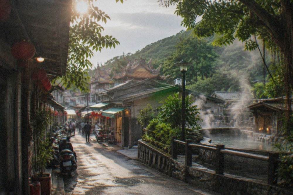 Steam rising from outdoor hot spring pools surrounded by green hills at Guanziling