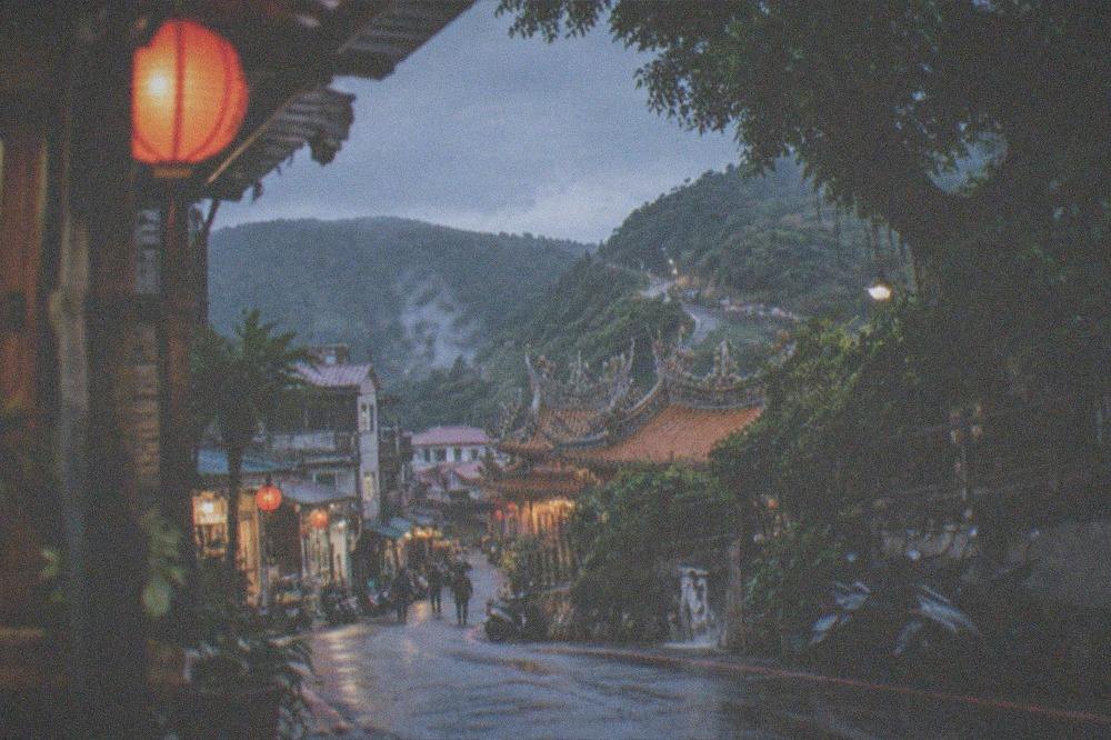 A mountain road winding through forested hills toward a hot spring town