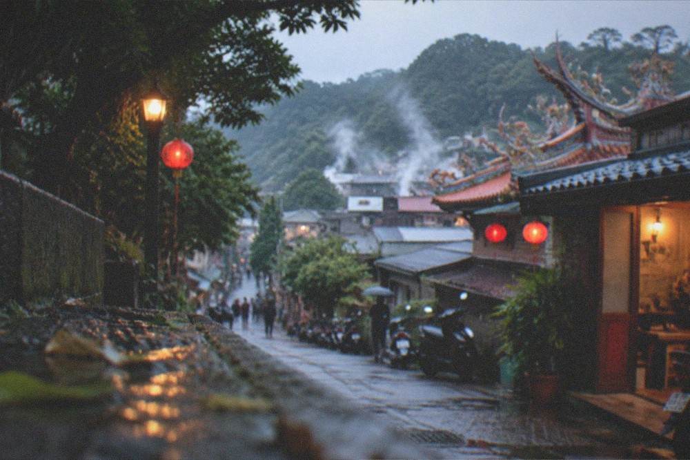 Steam rising above rooftops in a hot spring valley on a clear morning