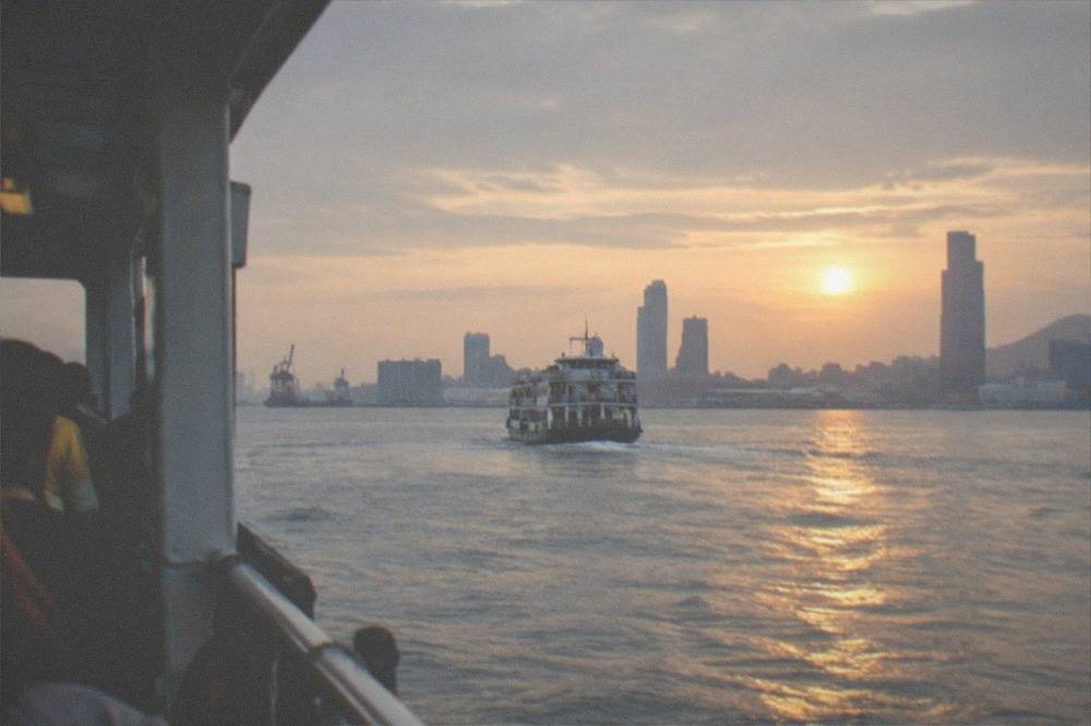 A ferry crossing the harbor mouth toward Cijin Island at golden hour