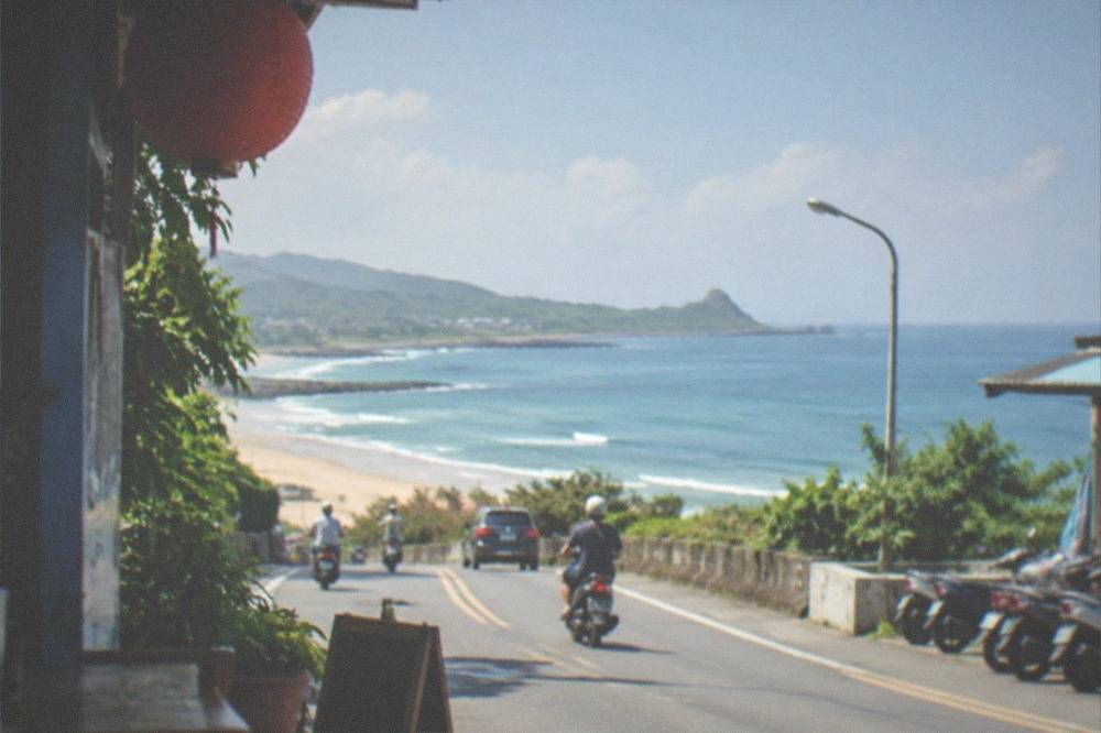 Food stalls with glowing signs along a pedestrian street in Kenting after dark