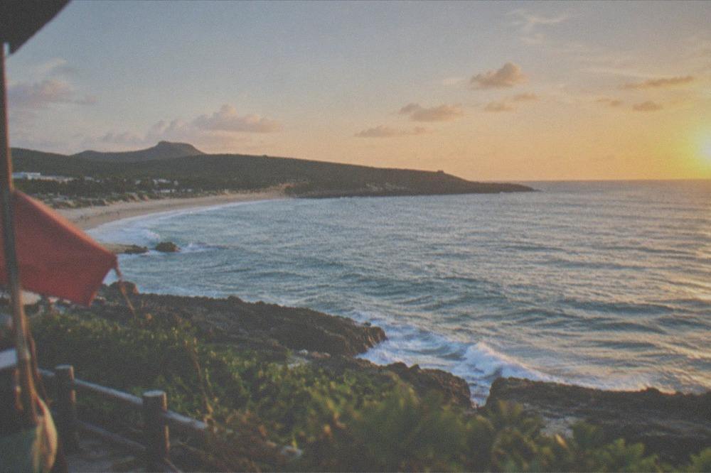 A white sand beach with rocky headland and waves along the Kenting coast