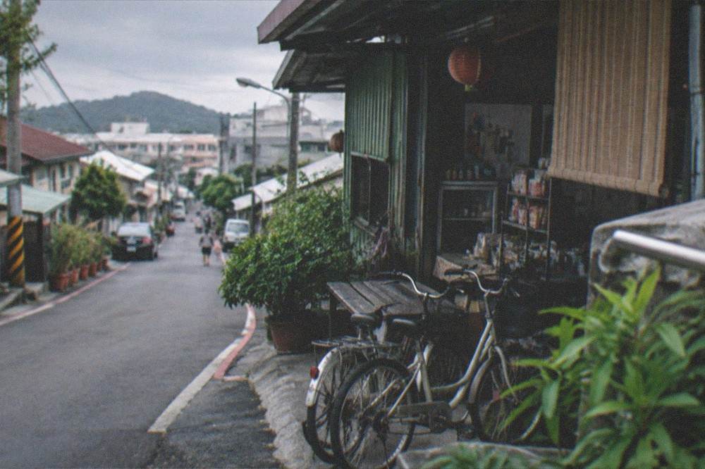 A quiet street corner with parked bicycles and a small shop