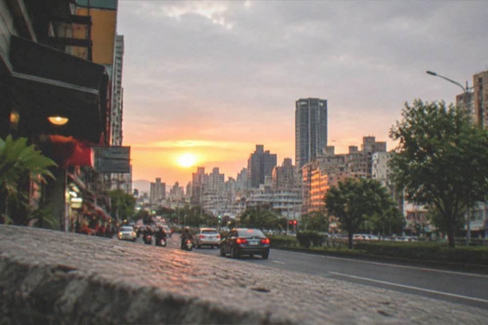 Sunset over a Taiwanese city skyline with warm light on rooftops