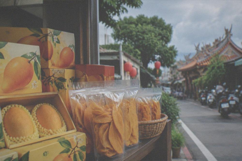 Preserved mango gift boxes and dried mango snacks arranged on a shop shelf
