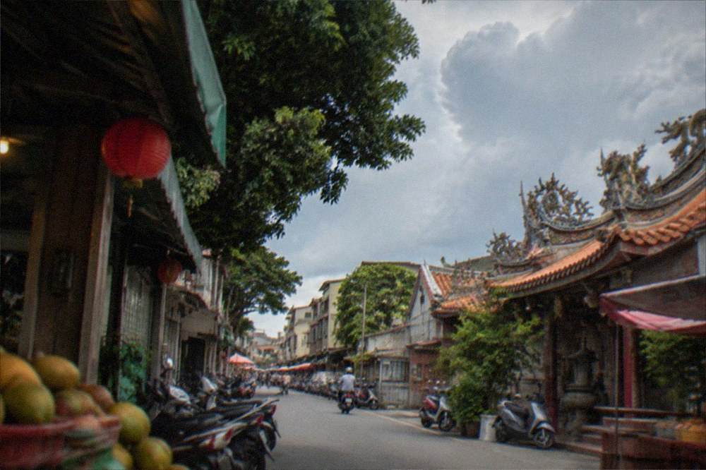 Terraced orchard slopes and distant hills in eastern Tainan under summer clouds