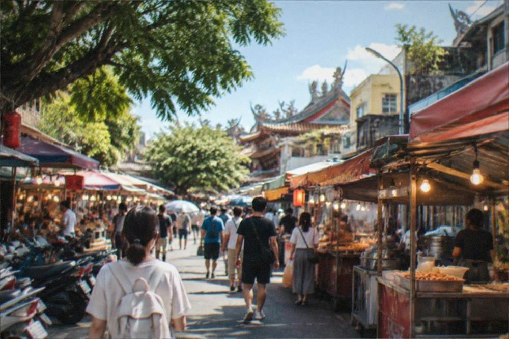 Crowds and food stalls under lights at a Tainan night market