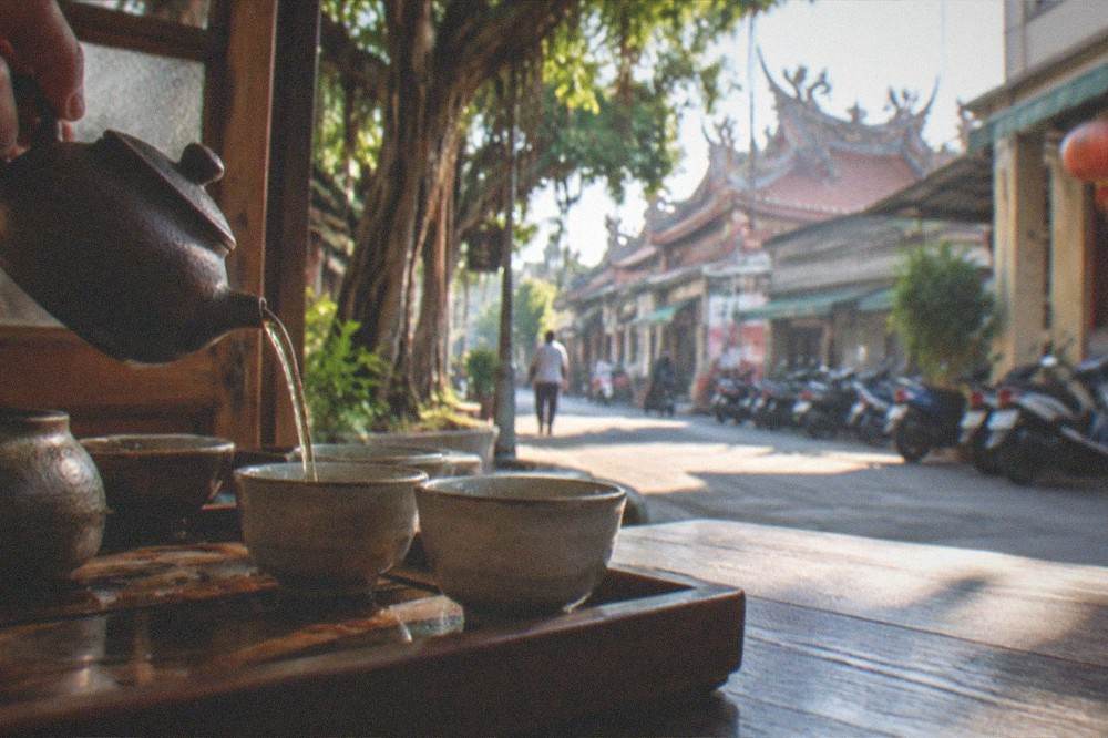 A small tea set with oolong tea being poured in a traditional interior