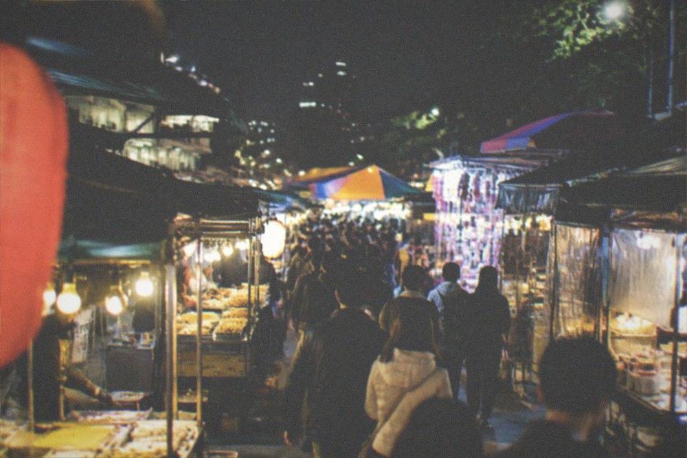 Crowded food stalls lit up at a Tainan night market after dark